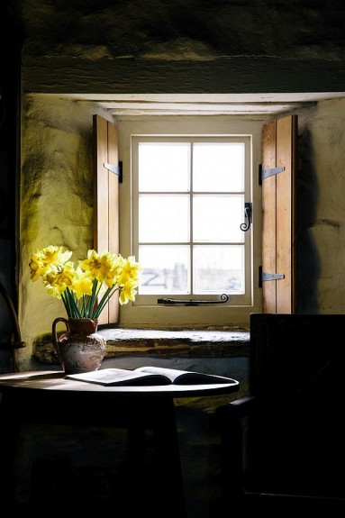 Małe okno z wewnętrzną okiennicą i piękny gliniany wazon na żonkile...