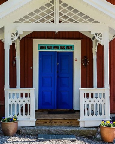 Szwedzki domek w typowych kolorach z zaskakującymi kobaltowymi drzwiami...