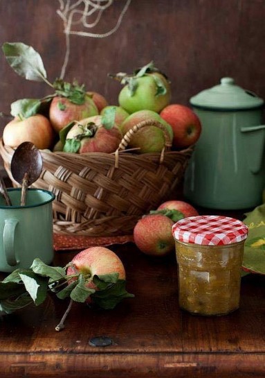 Kosz pełen jabłek i emaliowane naczynia w seledynowym kolorze...